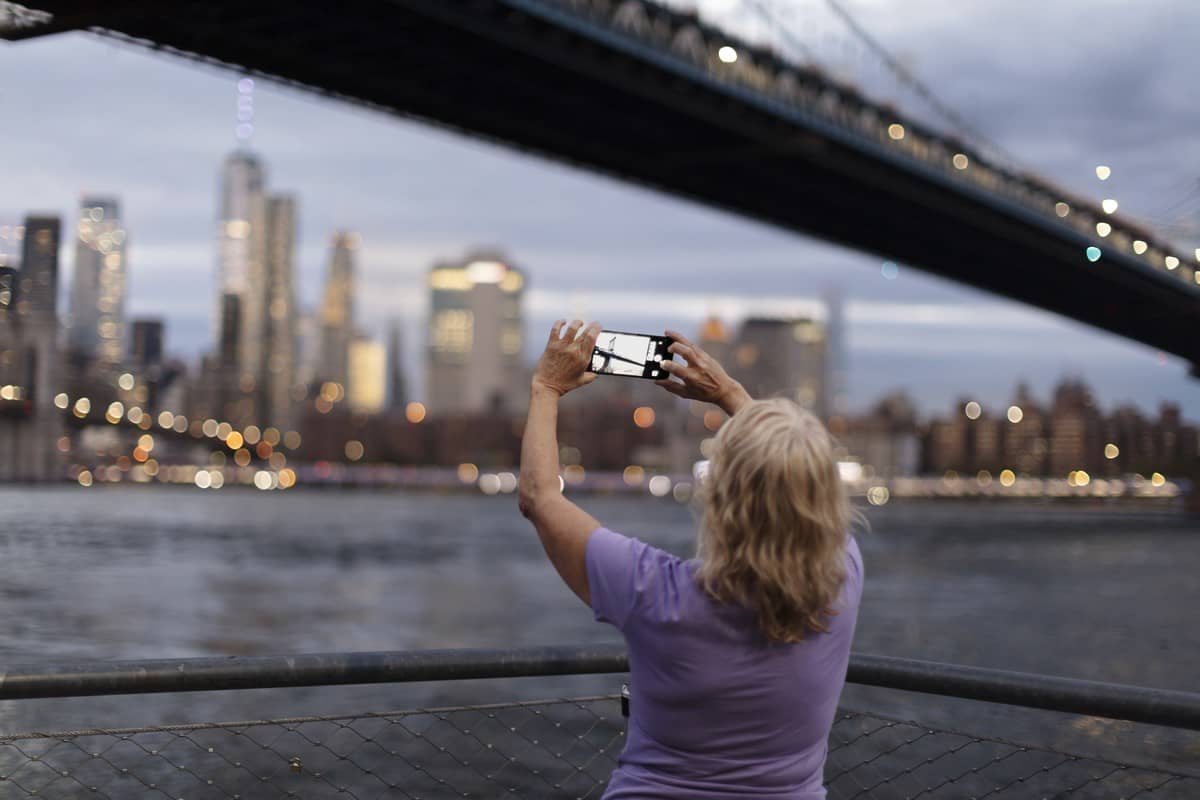Une femme en voyage à New York prend une photo de Manhattan