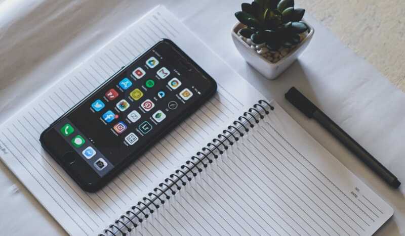 un smartpohne posé sur un bloc notes