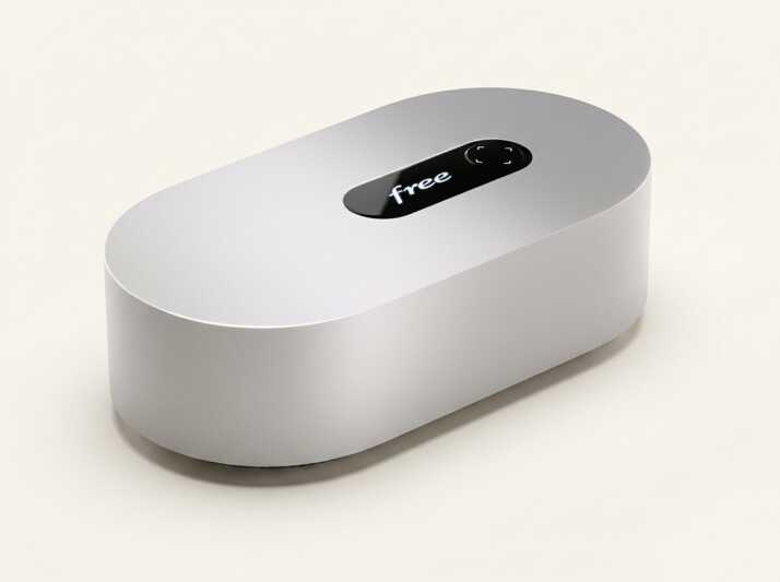 Box internet Free de forme ovale avec un écran tactile sur le dessus sur fond beige.