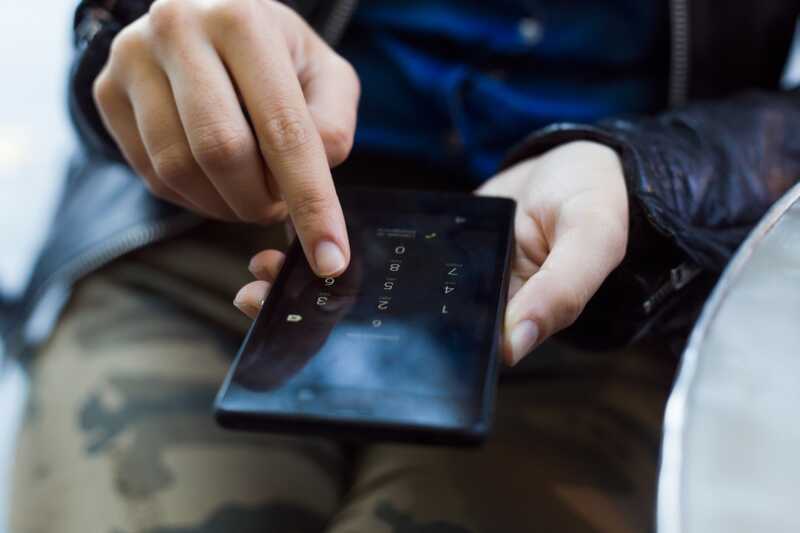 Une personne tape son code de sécurité sur son téléphone