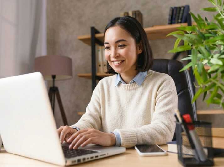 Une personne travaille sur un ordinateur portable à un bureau.