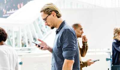 deux hommes debout avec leur smartphone en main