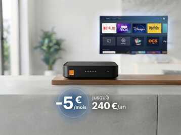 Décodeur TV Orange posé sur un meuble avec une télévision affichant des applications de streaming.