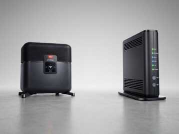 Une Livebox et un boîtier ONT Orange posés sur une surface grise avec un fond neutre.