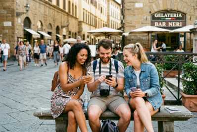 Trois personnes utilisant des smartphones en voyage à l'étranger.