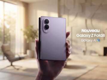Main tenant un smartphone Samsung Galaxy Z Fold8 violet avec le texte Galaxy AI sur fond de salon.