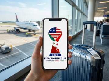 Smartphone affichant le logo de la Coupe du Monde FIFA 2026 devant un avion et une valise dans un aéroport.
