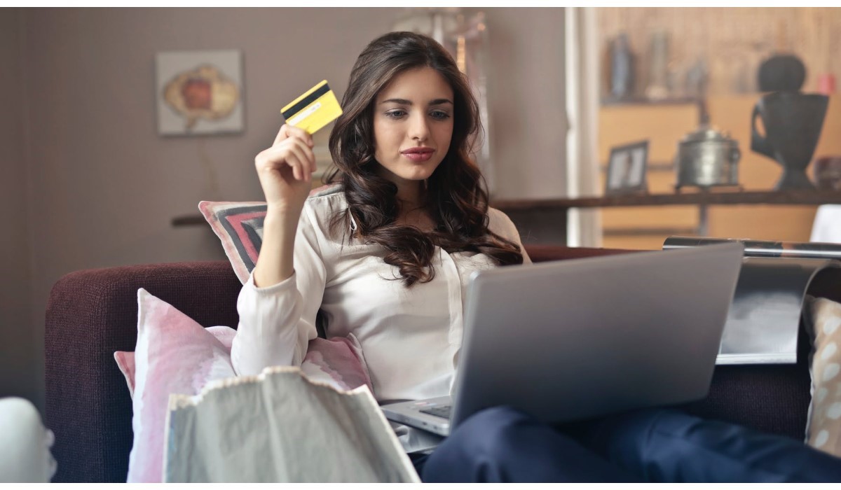 jeune femme  qui effectue des achats sur internet avec sa carte bancaire