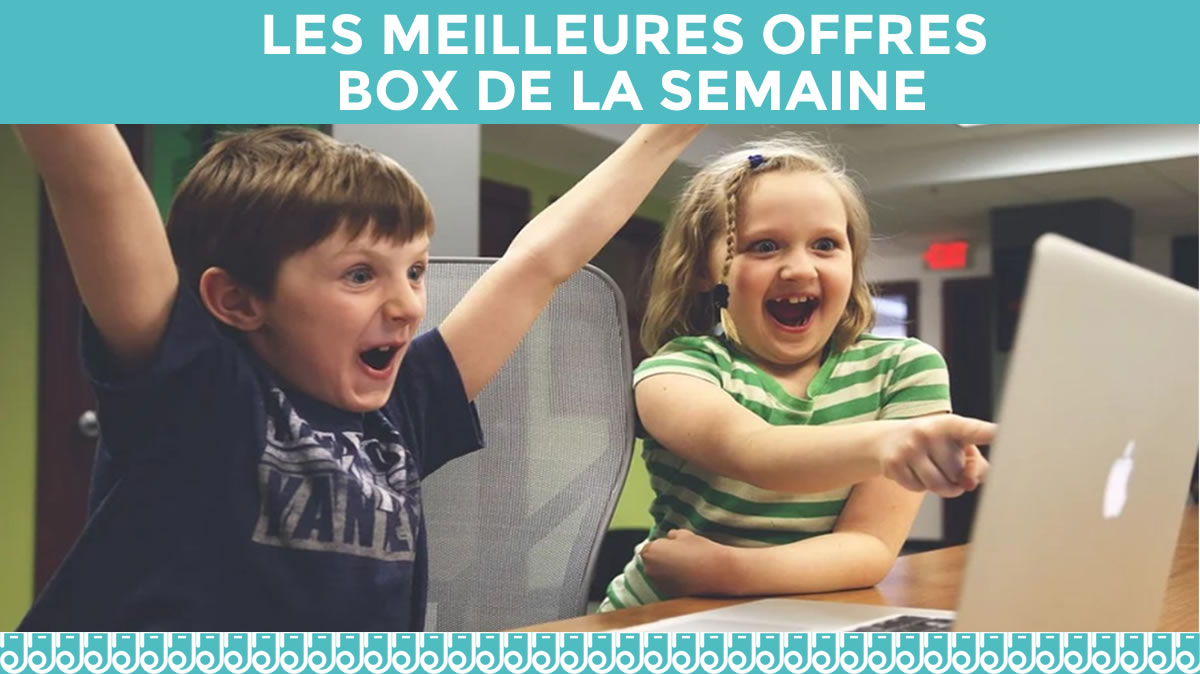 2 enfants contents avec bras levés devant un ordinateur