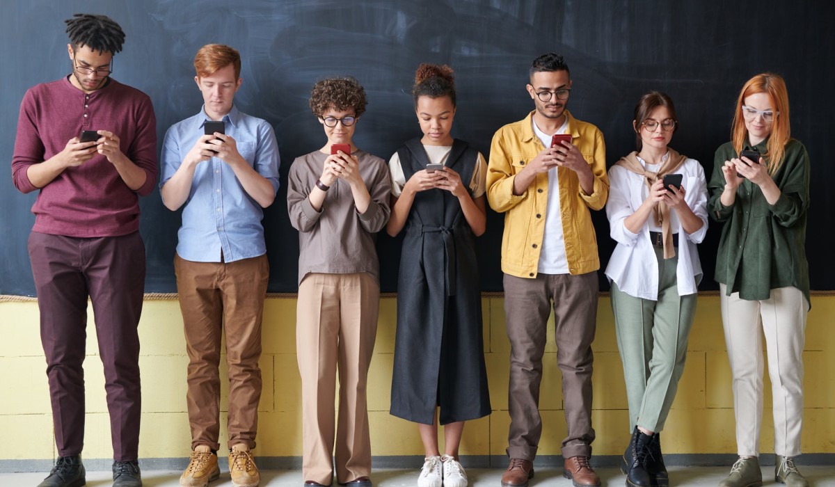 plusieurs personnes debout avec leur smartphone a la main