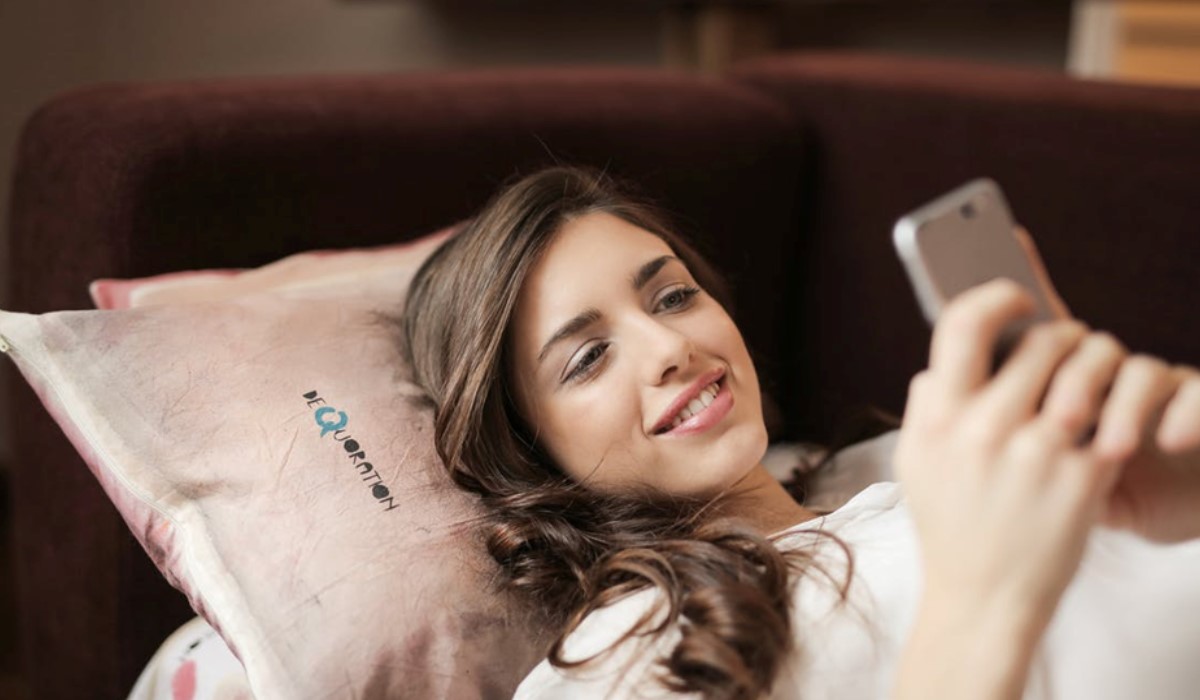 Jeune femme allongée avec son smartphone