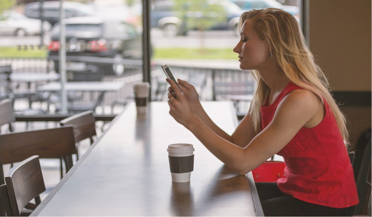 jeune femme dans un café avec son smartphone