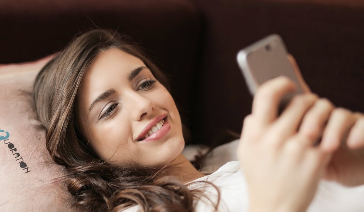 jeune femme allongé avec son smartphone en main