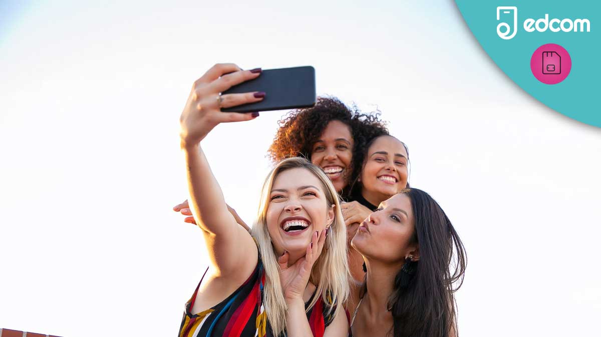 4 filles qui se prennent en photo avec leur smartphone dehors