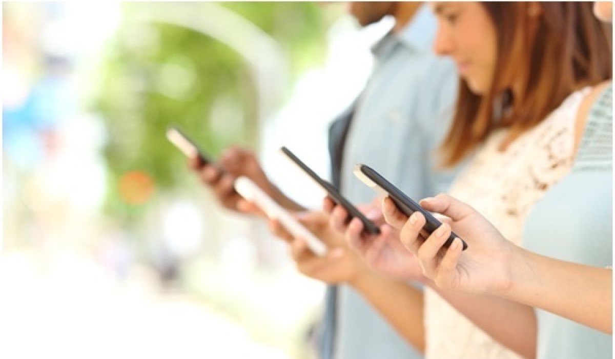 quatre personnes debout qui surfent sur son smartphone